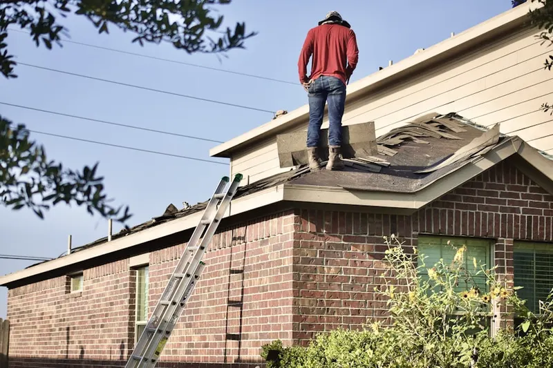 Professional roofer working on a residential roof in Fox Lair